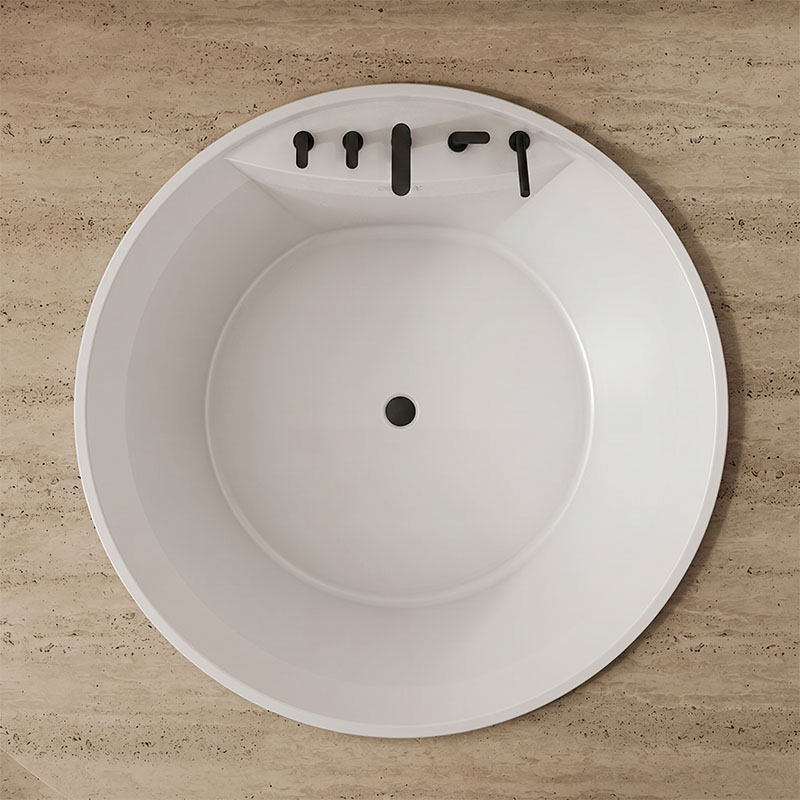 Top down view of a round white bathroom sink basin with a centered drain hole and black faucet knobs along the back edge